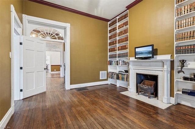 unfurnished living room with ornamental molding, hardwood / wood-style floors, and built in features