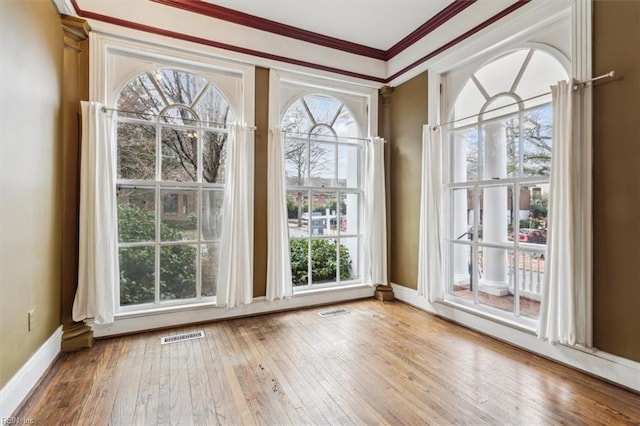 doorway with ornamental molding and wood-type flooring