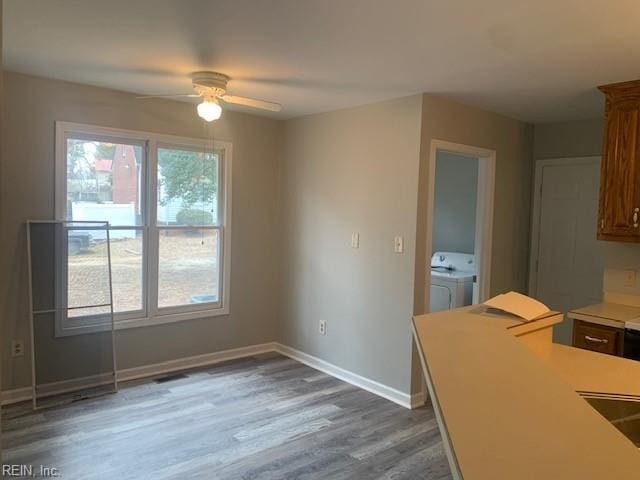 unfurnished dining area with washer and clothes dryer, dark hardwood / wood-style floors, and ceiling fan