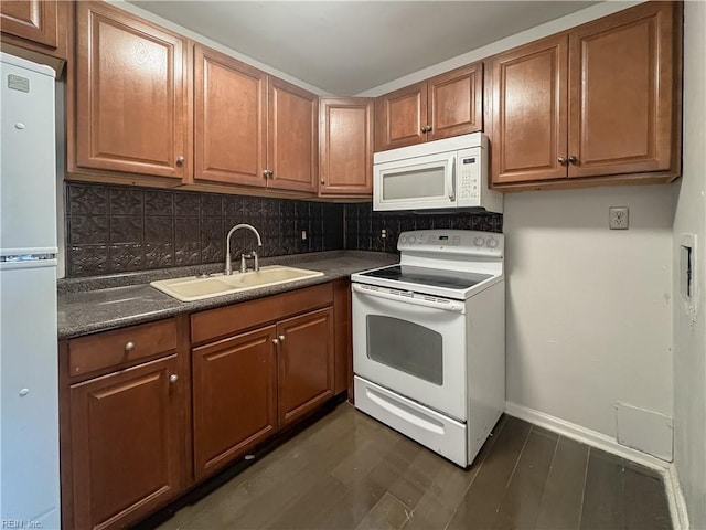 kitchen with white appliances, dark hardwood / wood-style floors, sink, and backsplash