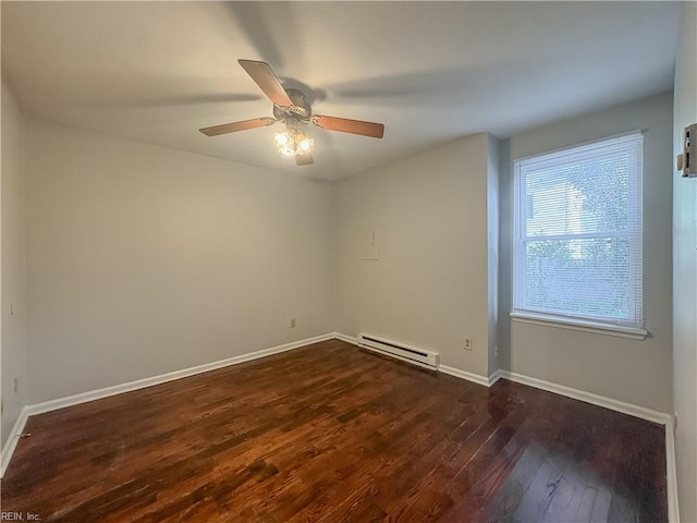 spare room featuring baseboard heating, ceiling fan, and dark hardwood / wood-style floors