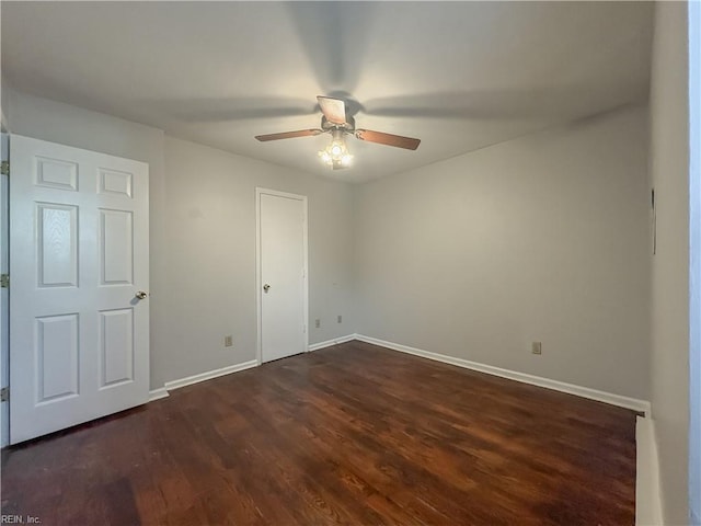 spare room featuring dark hardwood / wood-style flooring and ceiling fan