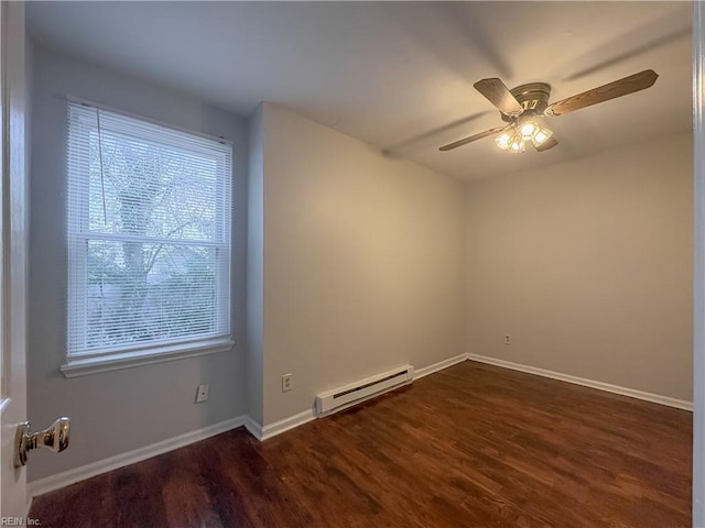 empty room featuring dark wood-type flooring, ceiling fan, and a baseboard heating unit