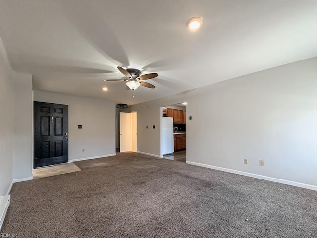 unfurnished living room with ceiling fan and dark colored carpet