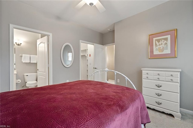 bedroom with ensuite bathroom, light carpet, and ceiling fan