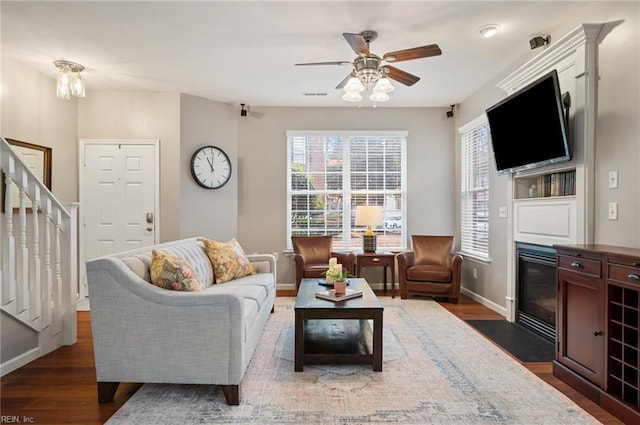 living room with dark wood-type flooring and ceiling fan