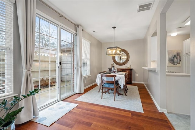 dining space featuring hardwood / wood-style flooring and an inviting chandelier