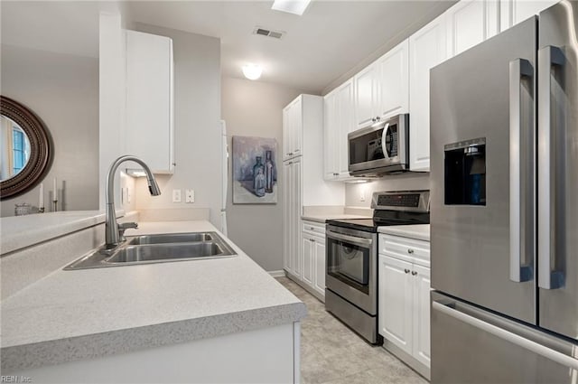 kitchen with white cabinetry, stainless steel appliances, and sink