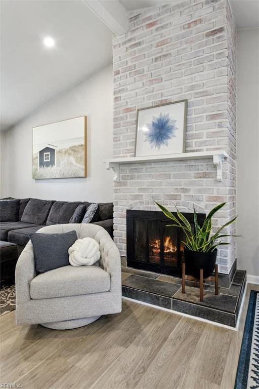 living room featuring hardwood / wood-style flooring, a fireplace, and lofted ceiling with beams