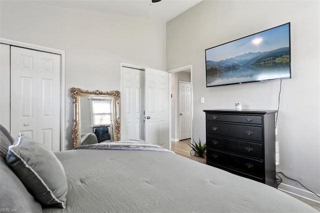 bedroom with light hardwood / wood-style floors and multiple closets