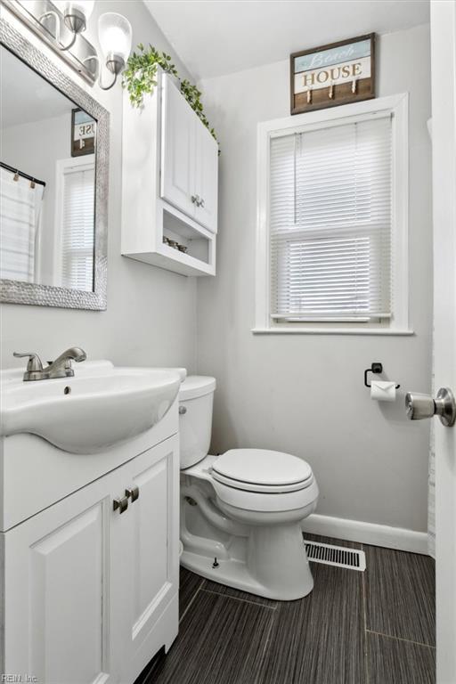 bathroom featuring vanity, hardwood / wood-style flooring, and toilet