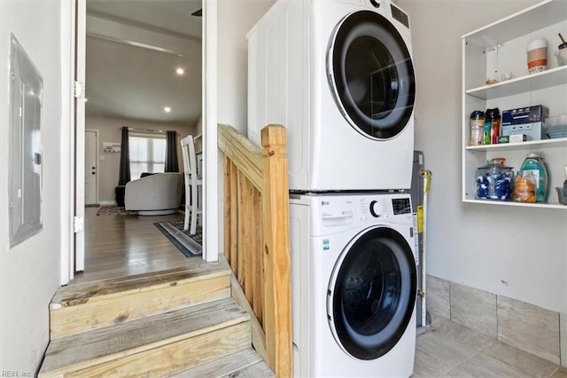 laundry room featuring stacked washer / dryer and light hardwood / wood-style floors