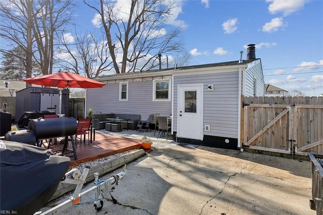 rear view of property featuring a storage unit and a deck