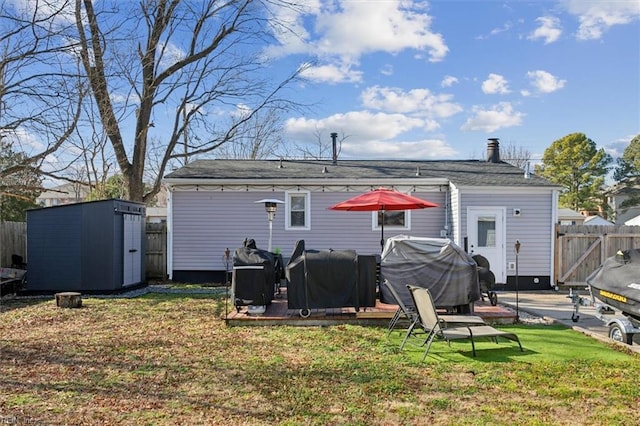 rear view of property with a lawn and a storage unit