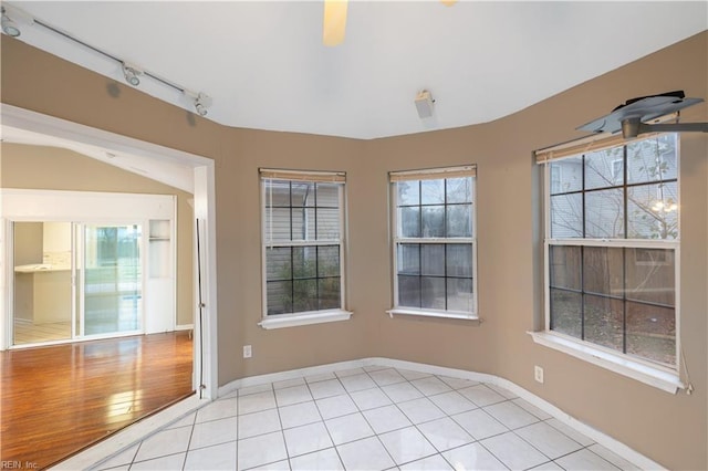 tiled empty room with a healthy amount of sunlight and rail lighting