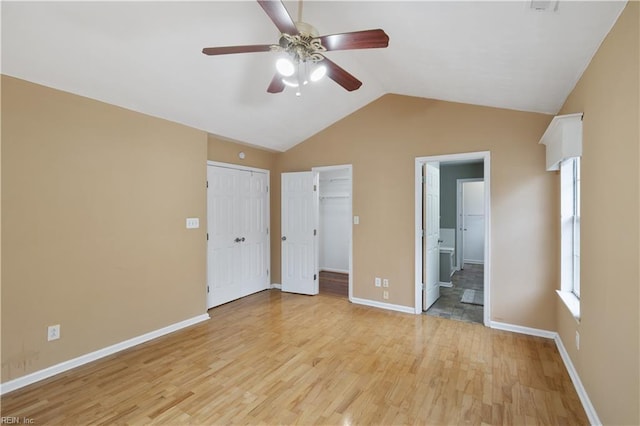 unfurnished bedroom with ensuite bathroom, lofted ceiling, ceiling fan, and light hardwood / wood-style flooring