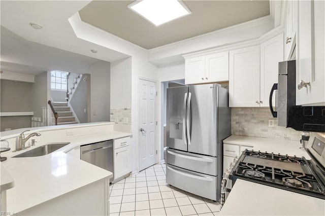 kitchen with sink, stainless steel appliances, kitchen peninsula, and white cabinets