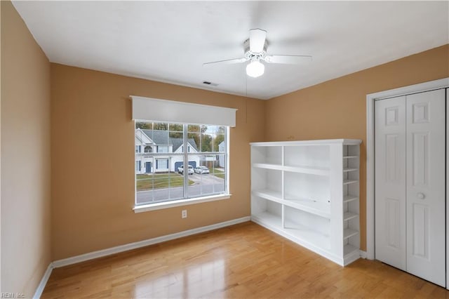 unfurnished bedroom with ceiling fan, a closet, and light hardwood / wood-style flooring