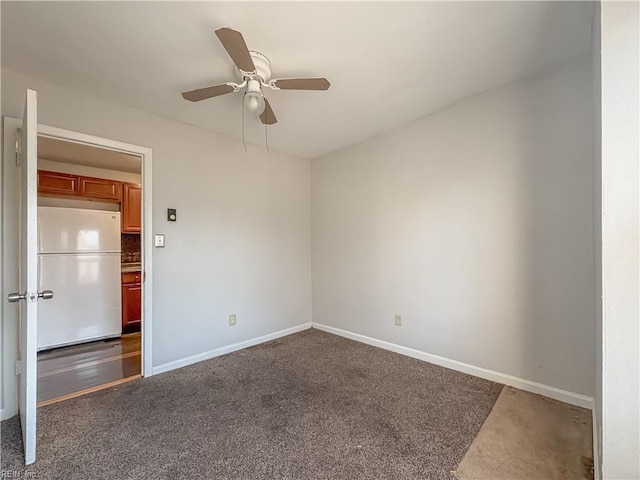 spare room with dark carpet and ceiling fan