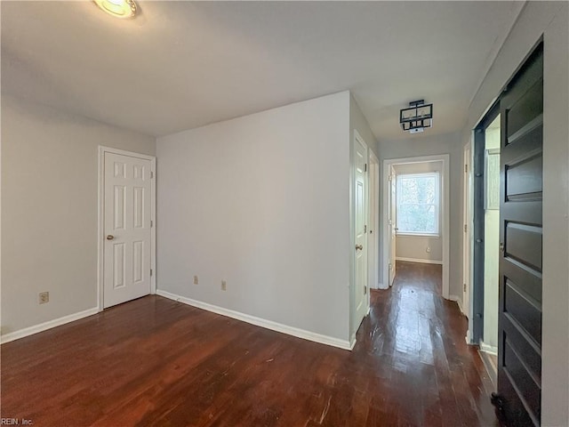 unfurnished room with dark wood-type flooring