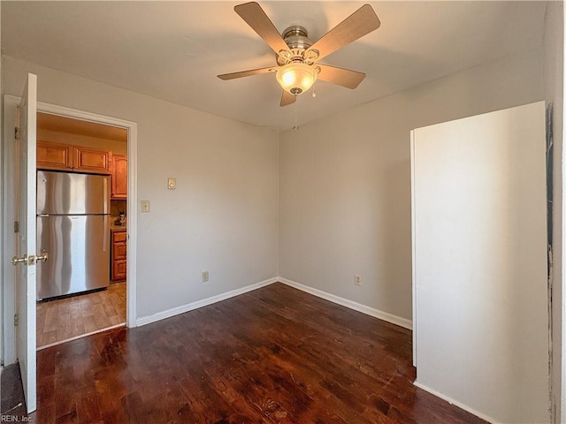 spare room with dark wood-type flooring and ceiling fan