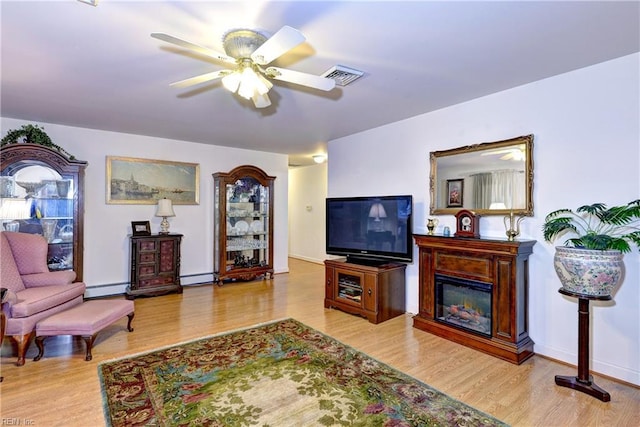 living room featuring ceiling fan, a baseboard radiator, and light wood-type flooring