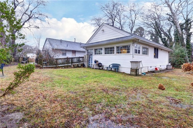 back of property with a yard and a deck