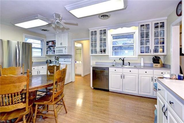 kitchen featuring white cabinetry, sink, ceiling fan, stainless steel appliances, and light hardwood / wood-style flooring