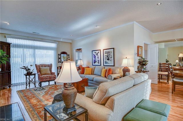 living room featuring crown molding, a textured ceiling, and light wood-type flooring