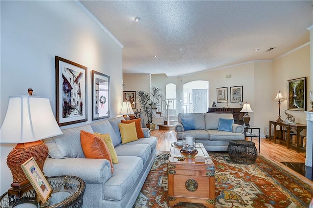 living room featuring hardwood / wood-style floors, crown molding, and a textured ceiling