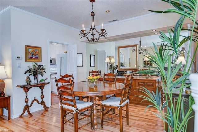 dining space with crown molding, a textured ceiling, and a chandelier