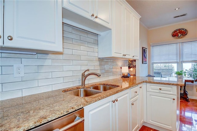 kitchen with sink, white cabinets, decorative backsplash, kitchen peninsula, and crown molding