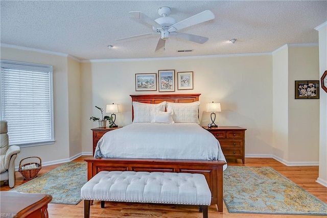 bedroom featuring ceiling fan, crown molding, light hardwood / wood-style floors, and a textured ceiling