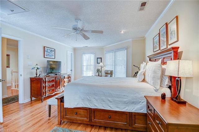 bedroom featuring crown molding, a textured ceiling, and light wood-type flooring