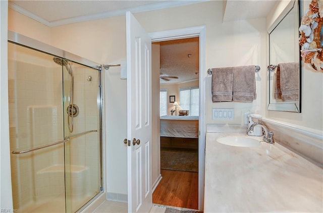 bathroom featuring a shower with door, ornamental molding, hardwood / wood-style flooring, and sink