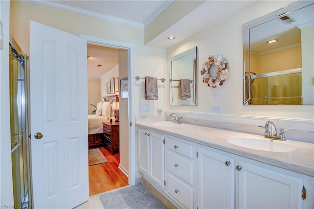 bathroom with crown molding, vanity, a shower with shower door, and hardwood / wood-style flooring