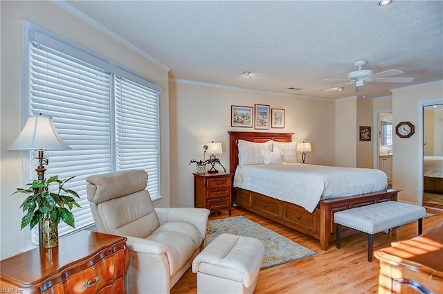 bedroom with ensuite bath, ornamental molding, a textured ceiling, and light wood-type flooring