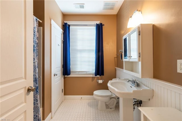 bathroom featuring sink, toilet, and tile patterned flooring