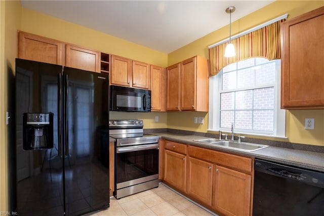 kitchen with sink, decorative light fixtures, black appliances, and light tile patterned floors