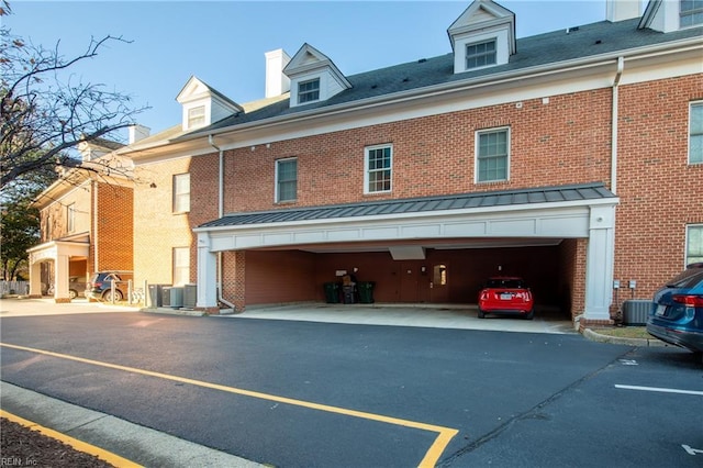 back of property with central AC and a garage