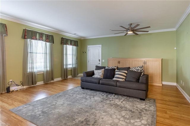 living room featuring wood-type flooring, ornamental molding, and ceiling fan