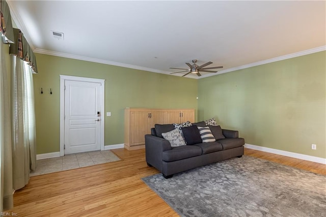 living room with ceiling fan, ornamental molding, and light hardwood / wood-style flooring