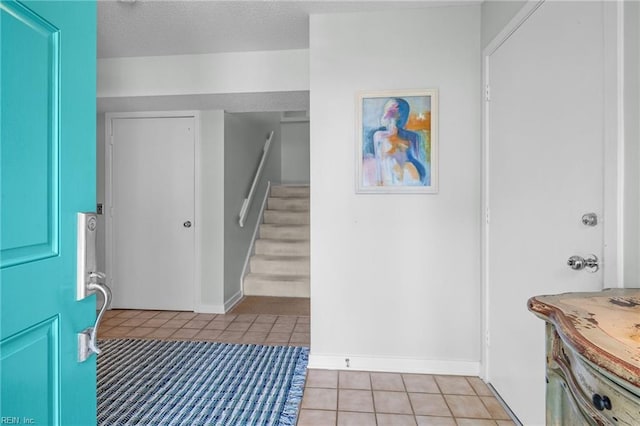 tiled entrance foyer featuring a textured ceiling