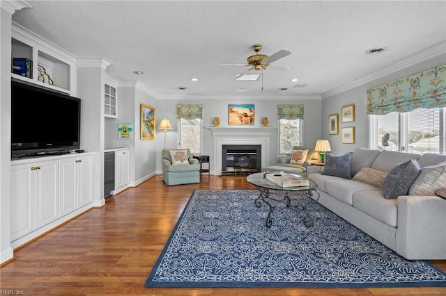 living room featuring hardwood / wood-style flooring, crown molding, plenty of natural light, and a textured ceiling