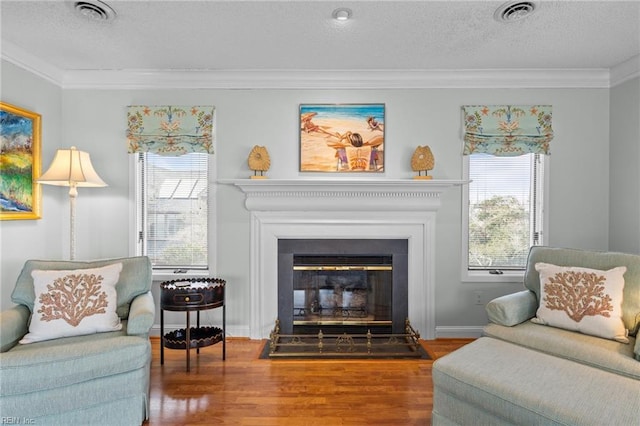 sitting room with ornamental molding, hardwood / wood-style floors, and a wealth of natural light