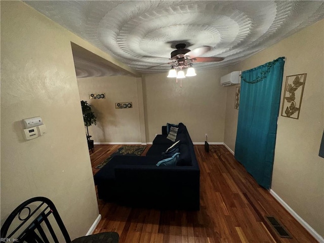 interior space featuring ceiling fan, dark hardwood / wood-style floors, and a wall mounted AC