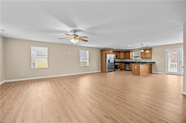 unfurnished living room with sink, light hardwood / wood-style flooring, and ceiling fan