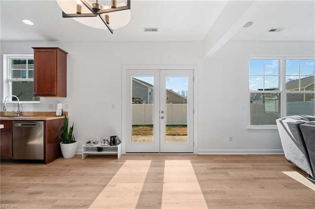 interior space featuring a healthy amount of sunlight, french doors, dishwasher, and light wood-type flooring