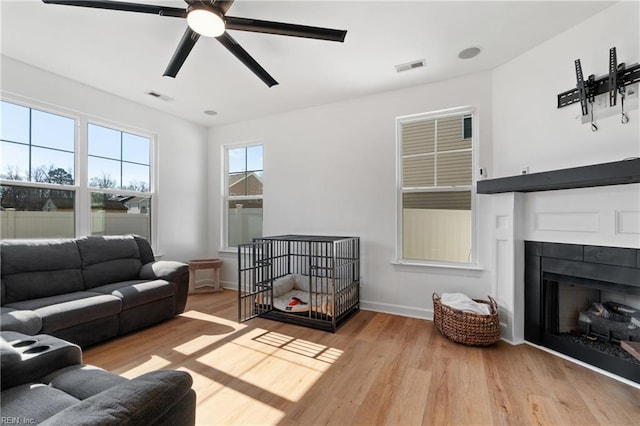 living room with light hardwood / wood-style flooring and ceiling fan