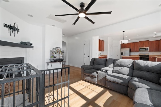 living room with ceiling fan and light wood-type flooring